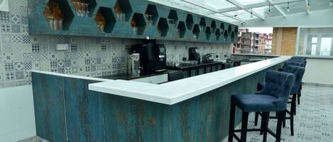 Una cocina moderna con barra, estantes hexagonales y azulejos estampados.