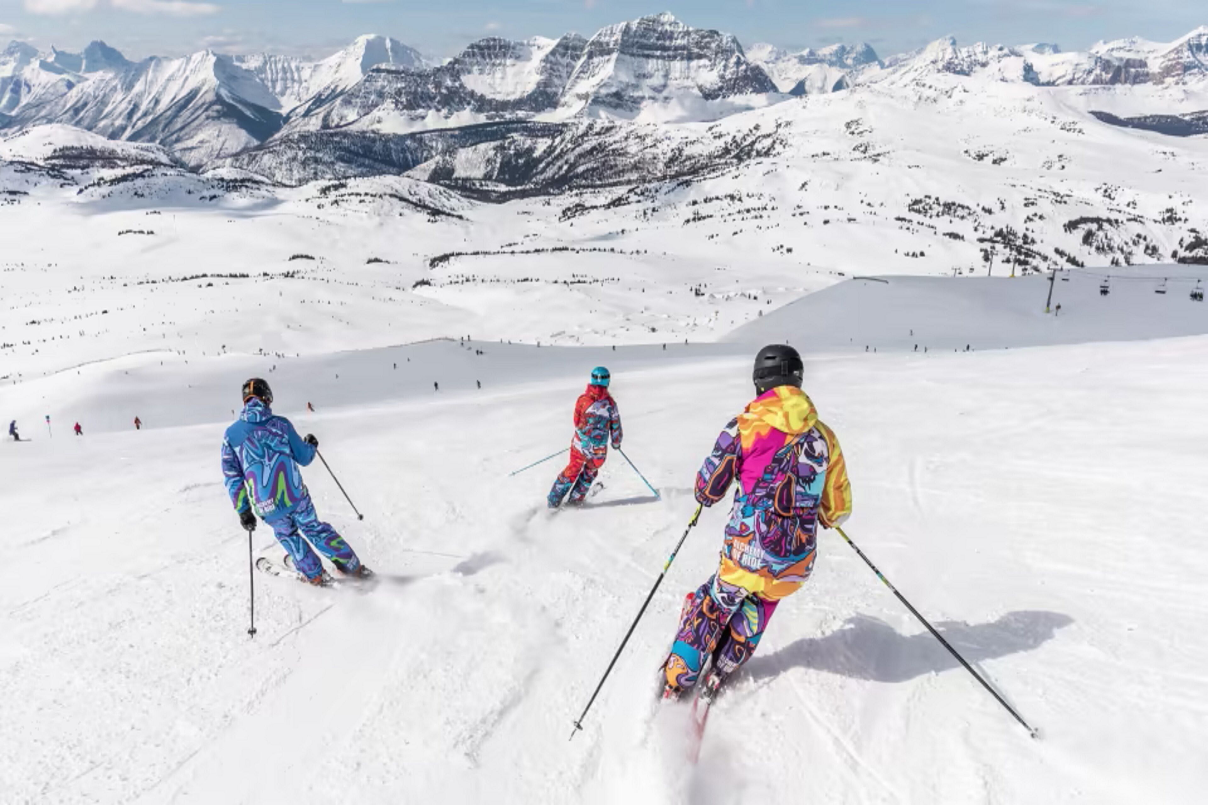 Un paysage de montagne enneigé avec des skieurs.