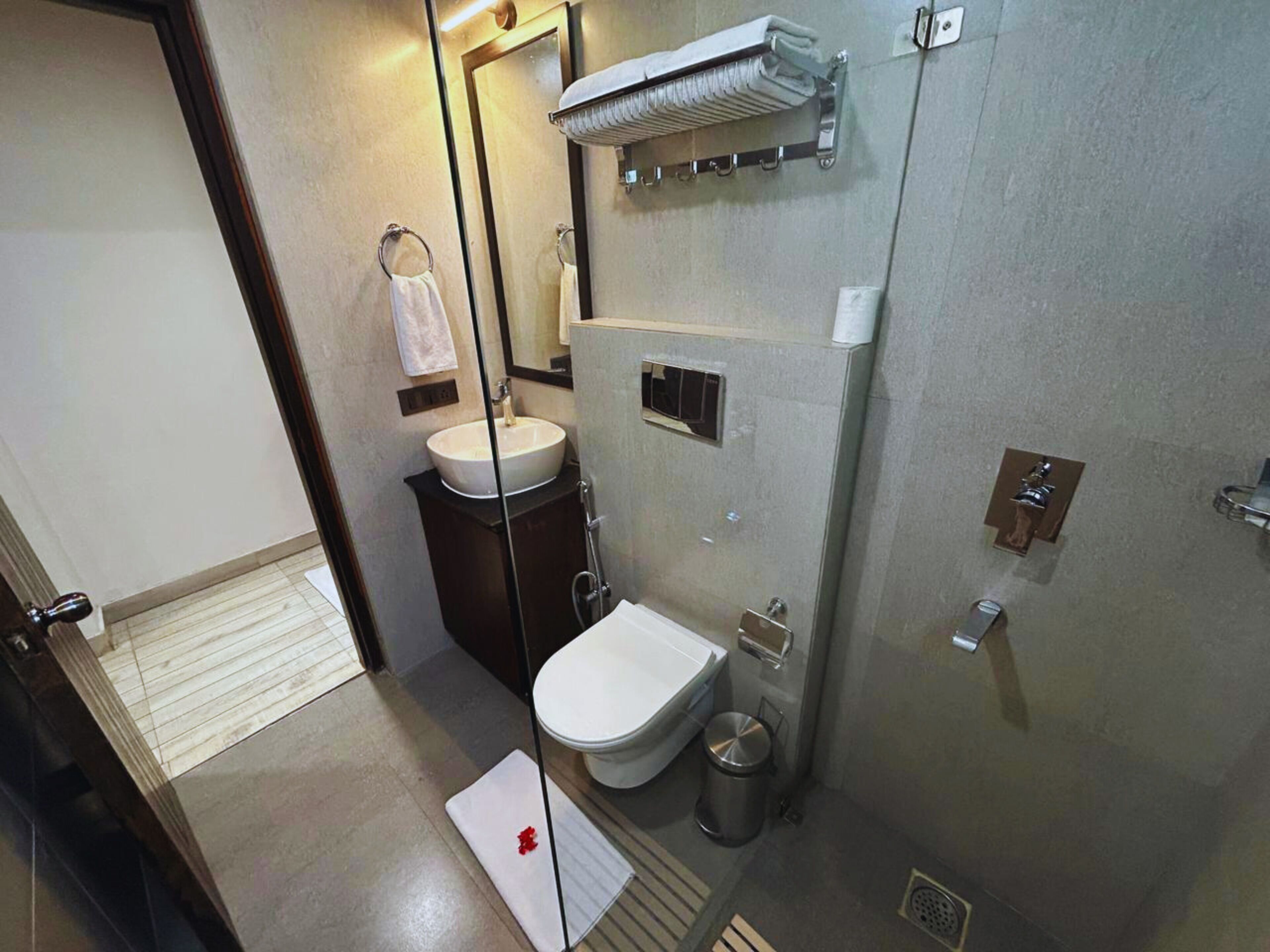 A compact bathroom with a sink, toilet, and shower.