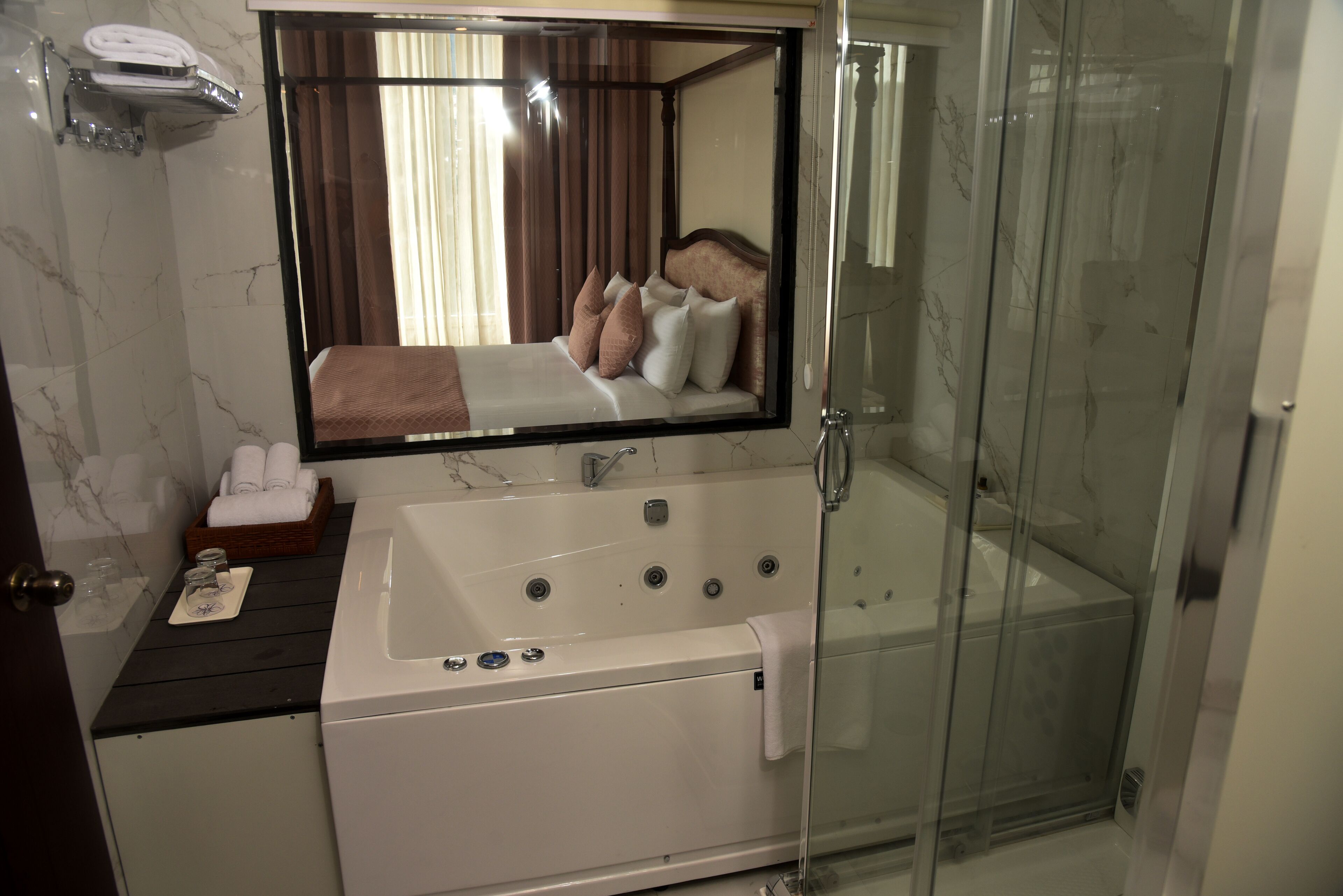 Une salle de bain moderne avec un grand miroir, une baignoire et une douche à parois de verre.