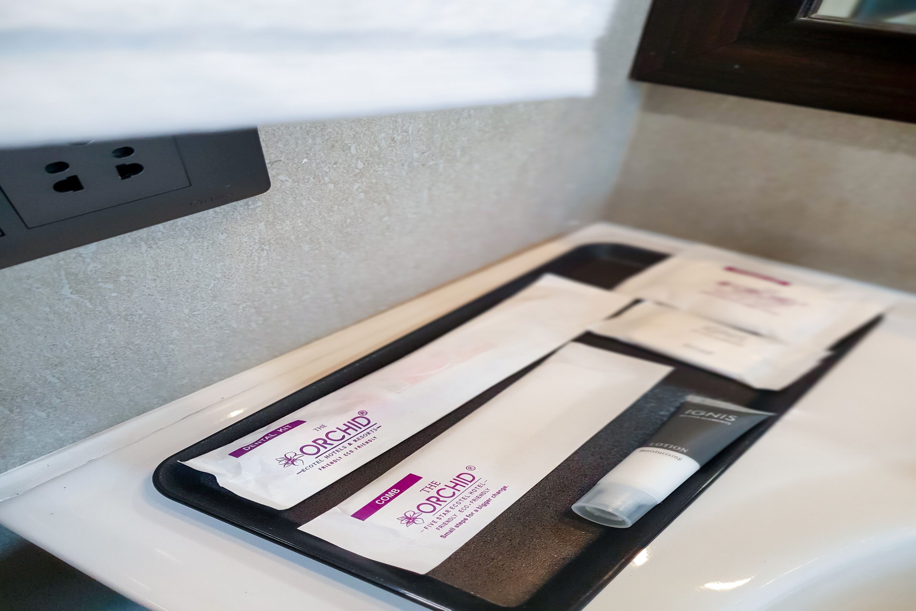 A tray with a skincare kit and a tube of lotion on a white countertop.