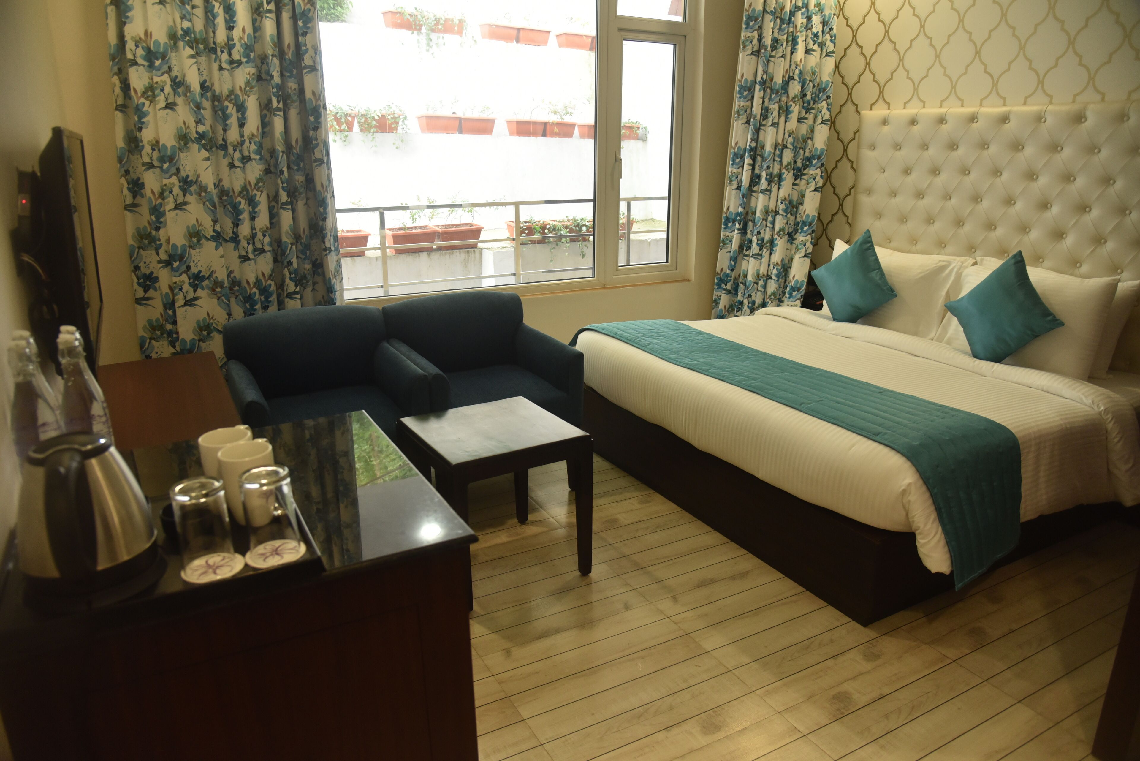 A hotel room with a bed, a sofa, a coffee table, and a TV.