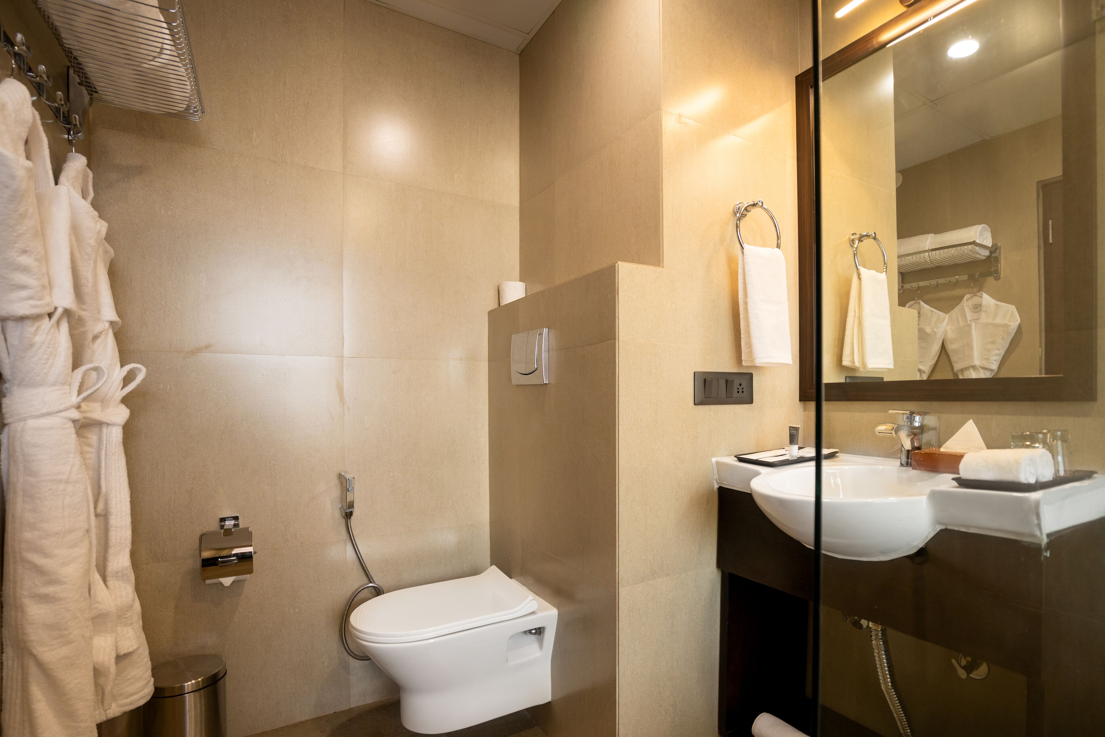 A modern bathroom with a toilet, sink, and glass shower enclosure.