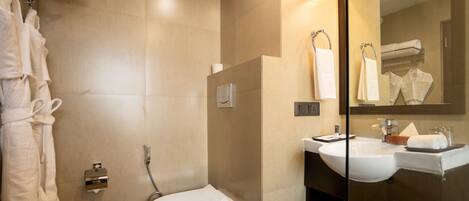 A modern bathroom with a toilet, sink, and glass shower enclosure.