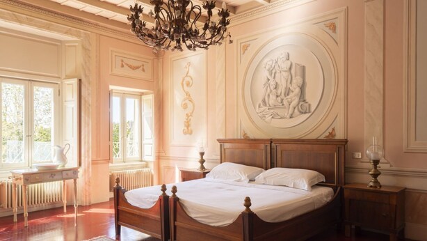 A classic bedroom with a wooden bed, a large window, and a decorative ceiling. - La Corte. A historic house at the gates of Bergamo. (Mozzo - (Bg))