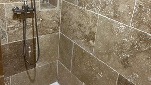 Baño con ducha, cabezal de ducha de mano y manguera de ducha.