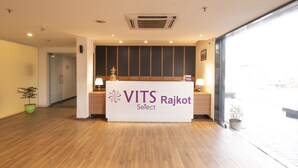 Una mesa de recepción con un letrero que dice "VITS Rajkot Select".