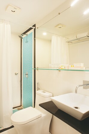 A bathroom with a toilet, sink, and shower.