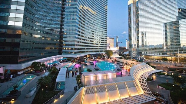 A modern hotel with a rooftop pool area, surrounded by high-rise buildings. - Perfect! Lux 1BR Suite at Vdara-15 (Las Vegas)