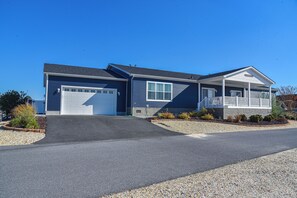 A two-story house with a garage, a covered porch, and a landscaped front yard.
