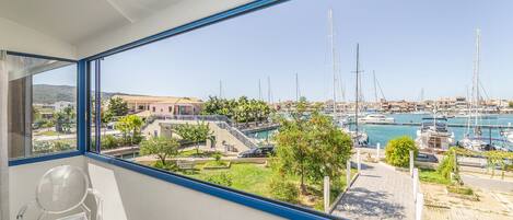 A balcony with a clear view of a marina, boats, and a building in the background.