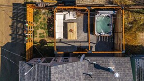 An aerial view of a backyard with a hot tub, a wooden deck, and a patio area. - Pine Street Retreat | 1BR Hot Tub Home, Dog Door, Walk to Main St | Leadville (Leadville)
