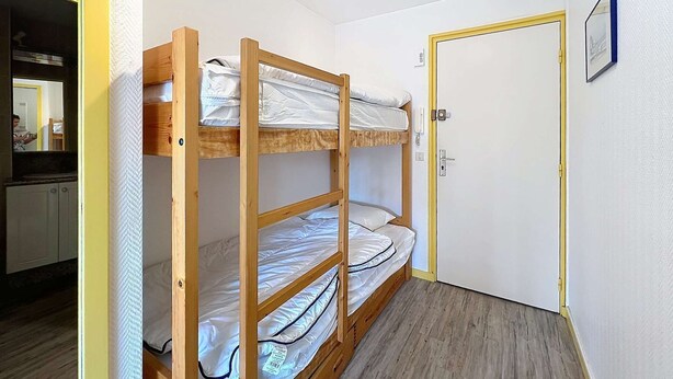 A bunk bed with three levels, a door with a handle, and a small framed picture on the wall. - Quiberon - 2rooms + duplex - 38m² - near beach (QUIBERON)