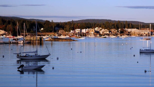 A harbor with boats, a small town, and forested hills in the background. - Western Mountain Townhouse (Southwest Harbor)