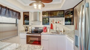 A compact kitchen with a stove, oven, and modern appliances. - Paradise - quiet, clean, upgraded condo; walk to beach (Marco Island)