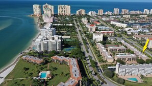 An aerial view of a coastal city with high-rise buildings, a beach, and a golf course. - Paradise - quiet, clean, upgraded condo; walk to beach (Marco Island)