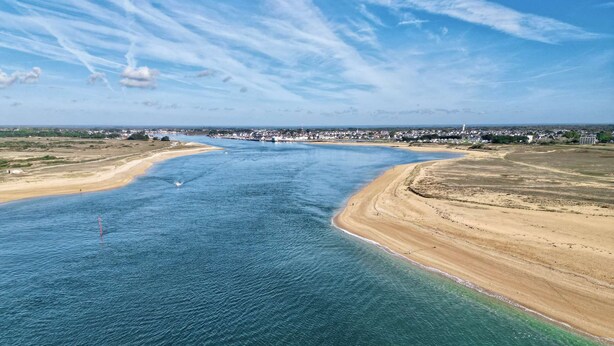 An aerial view of a coastal area with a wide beach, a clear blue sea, and a distant town with buildings. - Etel - 2-room apartment - 40m² - Wifi - 3* (ETEL)