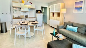 A modern apartment with a dining area, kitchenette, and living room. - Etel - 2-room apartment - 40m² - Wifi - 3* (ETEL)