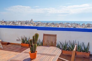 Una terraza en la azotea con vistas a la ciudad y al mar.