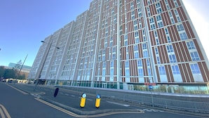 A modern high-rise building with a grid of windows and a flat facade.