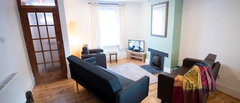 A living room with a sofa, a television, and a fireplace.