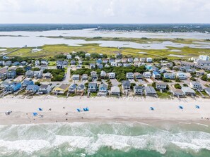 A coastal residential area with houses, a beach, and a water body.