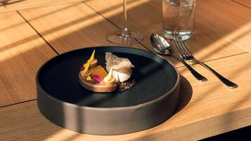 A dining table with a dessert plate, a wine glass, and a water glass.