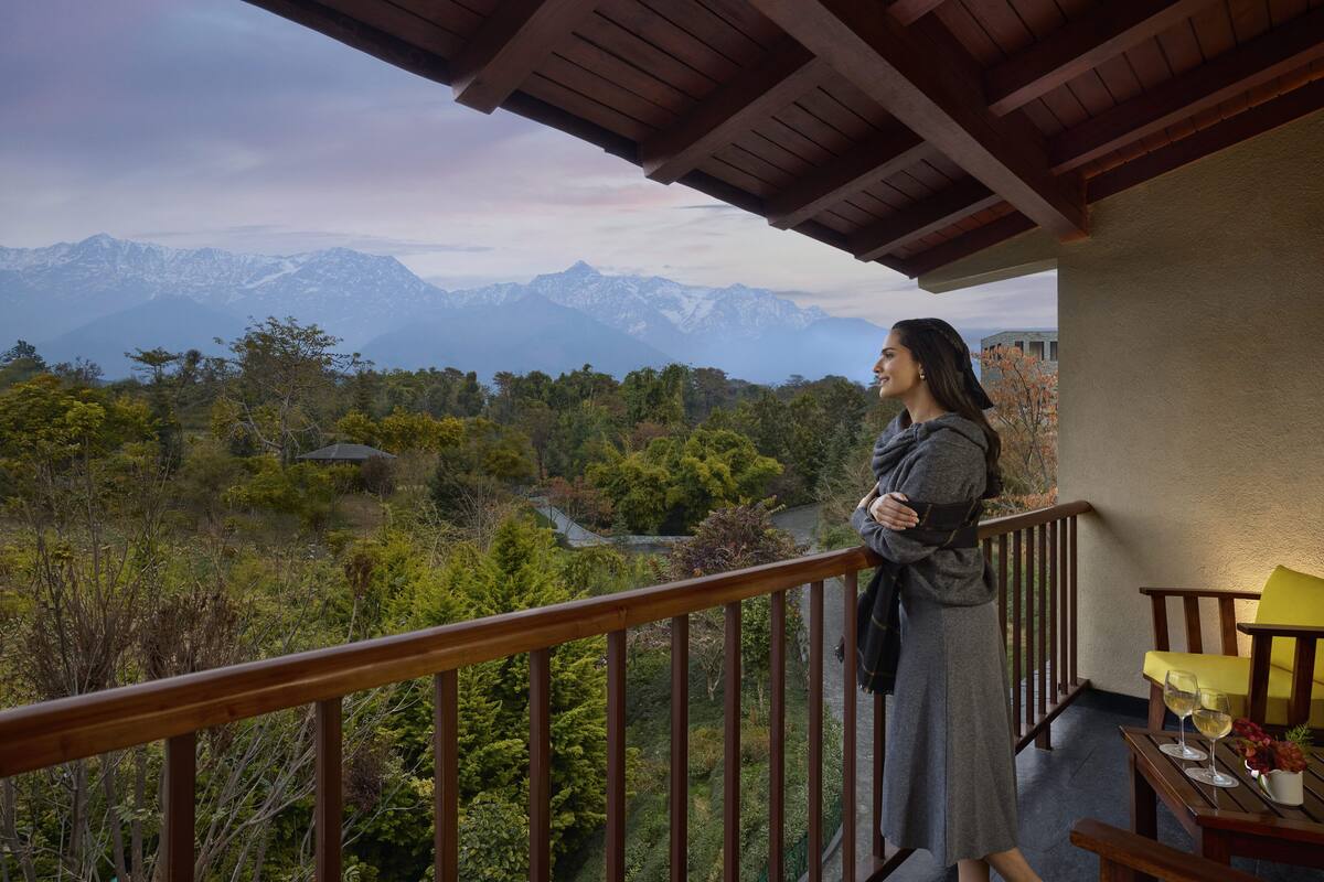 Uma varanda com vista para montanhas e uma floresta.