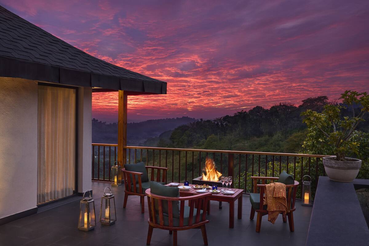 Um terraço com lareira, espaço para sentar e vista para a paisagem.