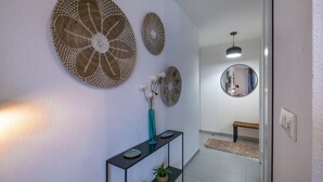 A hallway with a console table, decorative wall art, and a mirror.