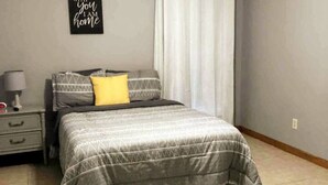 A bedroom with a bed, a nightstand, a lamp, and a wall decoration. - Newly Remodeled, Family Home, Near Interstate (Sulphur)