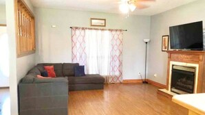 A living room with a sectional sofa, a fireplace, a television, and a ceiling fan. - Newly Remodeled, Family Home, Near Interstate (Sulphur)
