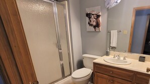 A bathroom with a glass shower door, a toilet, a sink with a vanity, and a towel rack. - Newly Remodeled, Family Home, Near Interstate (Sulphur)