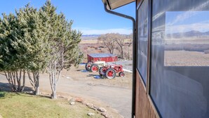A view of a rural landscape with a barn, tractors, and a clear sky. - 20+ Acres of Peace @ The Saratoga Hoemstead (Encampment)