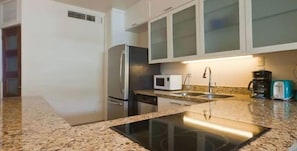Enjoy cooking in this well-equipped kitchen with a central island, stovetop, and stainless steel appliances.