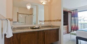 Enjoy a stylish retreat with a large mirror, chandelier, and comfortable bed.