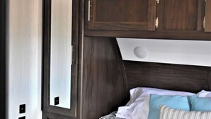 Une chambre à coucher avec un lit, des oreillers et une fenêtre.