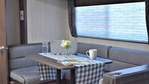 Un intérieur chaleureux avec une table à carreaux, un ordinateur portable, un vase de fleurs et une tasse.