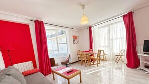 Een moderne woonkamer met een bank, salontafel en een eethoek.