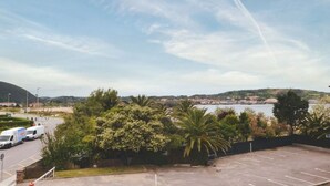 Un parking offrant une vue sur un plan d’eau et des collines au loin.