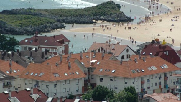A coastal town with buildings and a beach.