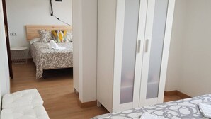 Ein Schlafzimmer mit Bett, Kleiderschrank, Nachttisch und Stuhl.