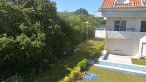 A residential building with a red-tiled roof, a well-maintained lawn, and a fence. - Apartamento con vistas - La Arena 4612 (Isla)