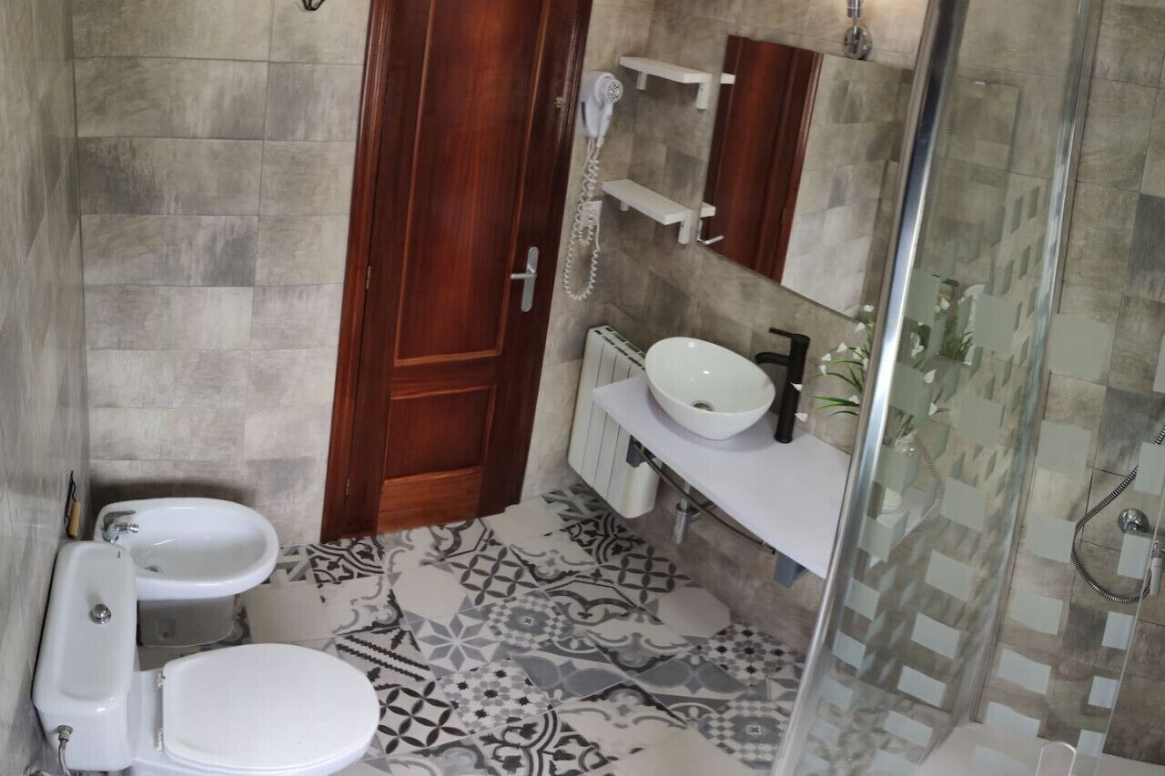 Un baño con inodoro, bidé y lavamanos.