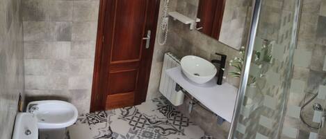 Un baño con inodoro, bidé y lavamanos.