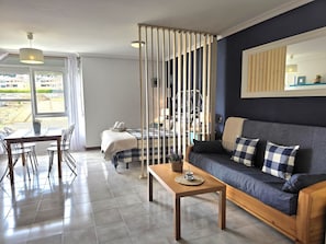 Un salon moderne avec un canapé, une table à manger et un lit.