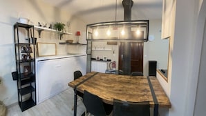 Eine moderne Küche mit einem Holztisch, schwarzen Stühlen und einer eingebauten Regaleinheit.