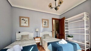 A hotel room with two beds, a white wardrobe, a nightstand, a lamp, and a ceiling fan. - Apartamento en Ris con garaje - Pineda 6405 (Noja)