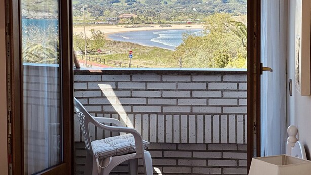 A balcony with a view of a beach and hills. - Apartment close to Ris Beach - Pineda 6606 (Noja)