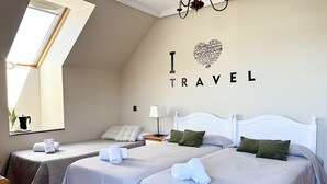 A hotel room with two beds, a skylight, a wall with 'I LOVE TRAVEL' text, and a chandelier. - Apartamento en playa de Ris - Pineda 6607 (Noja)